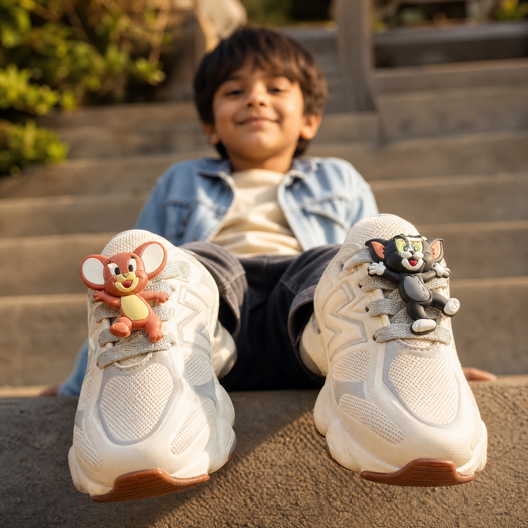 Niño sentado en escalones con tenis Tom y Jerry