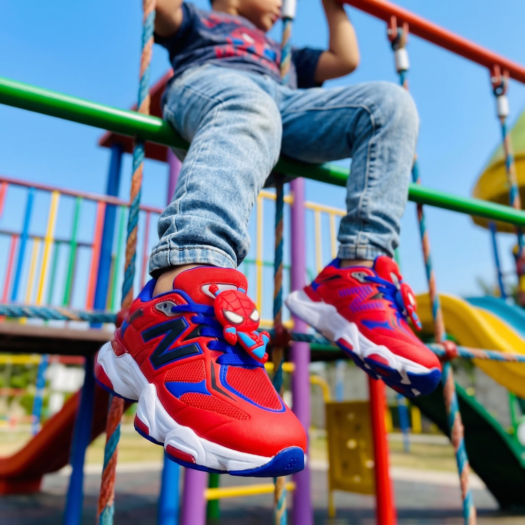 Niño trepando en los juegos con los tenis